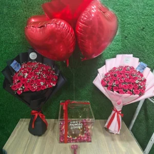 Two 50-stem red rose bouquets (black and pink wrap) with heart balloons and personalized gift box